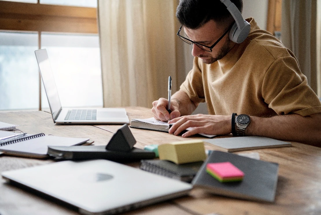 Hombre sentado en un escritorio con una computadora portátilEl contenido generado por IA puede ser incorrecto.